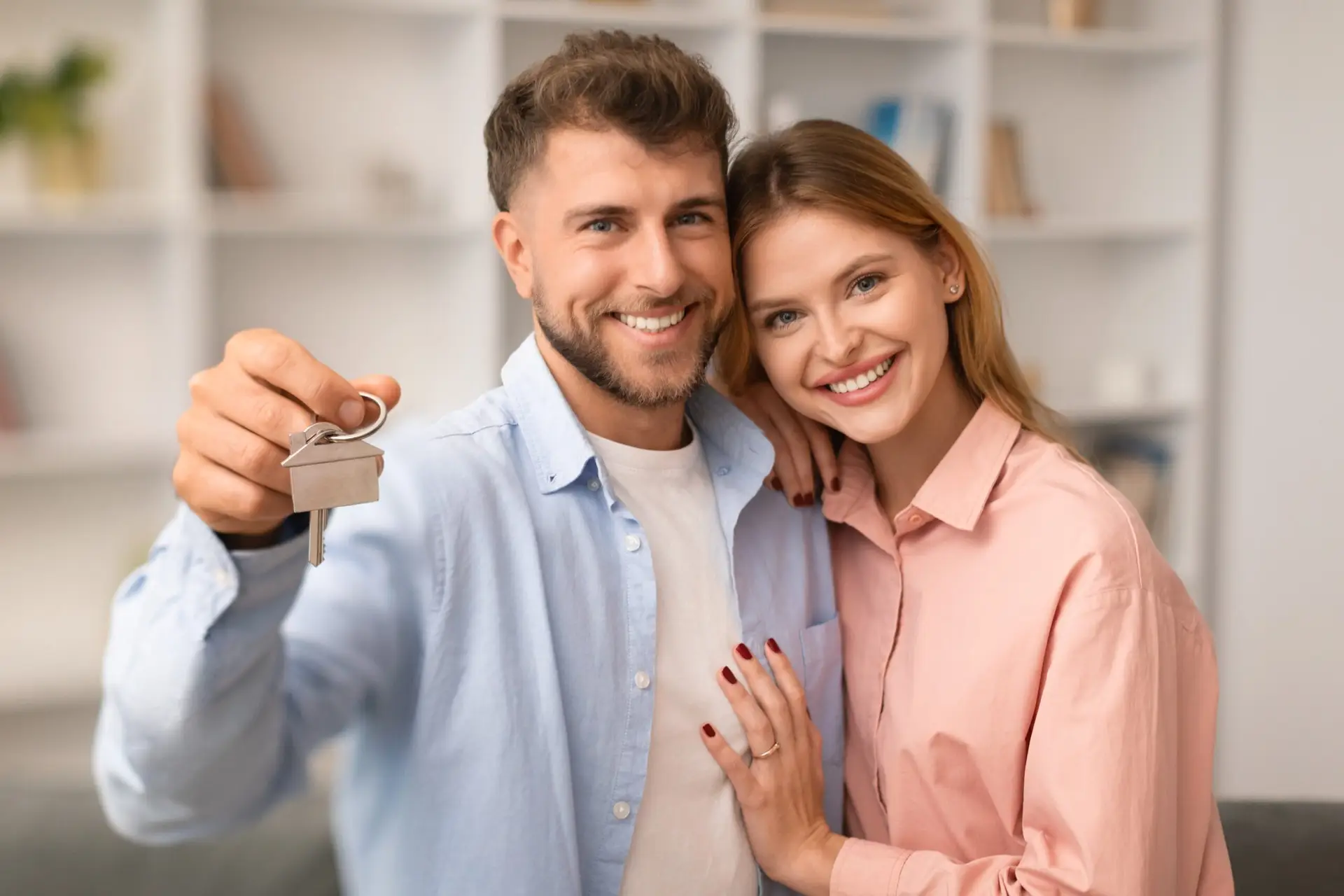 Young couple celebrating home ownership, highlighting comprehensive homeowners insurance for protecting life's most valuable asset