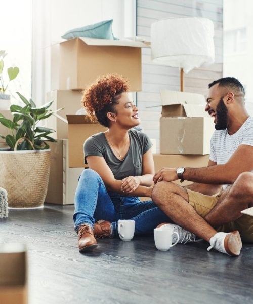 Young couple unpacking in their new home, showcasing the peace of mind renters insurance provides