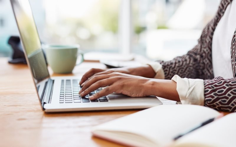 Cropped shot of an unrecognizable woman using her laptop while sitting at her desk